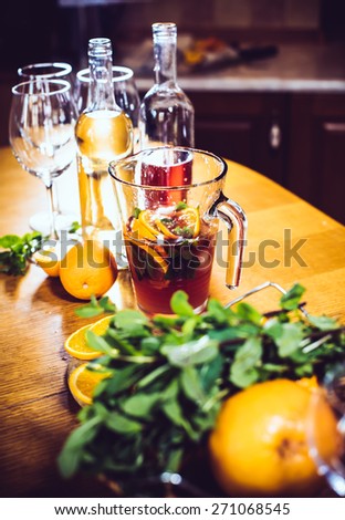 Large jar of sangria with red wine, oranges and ice for home party, home kitchen interior. Homemade food and drinks
