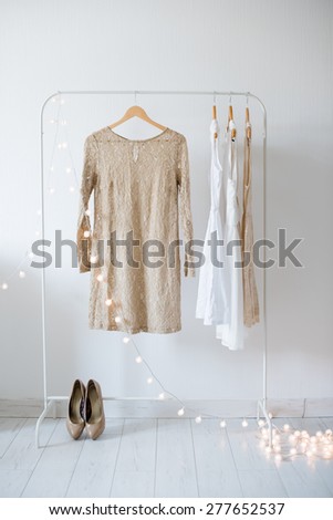 Summer dress, vintage wooden door, basket and decorative lights, girl\'s room interior decoration with white walls and floors.