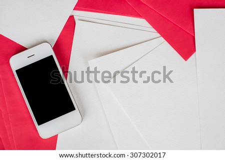 Smartphone and clean empty white and red paper sheets on office table with copy space, business and communication background