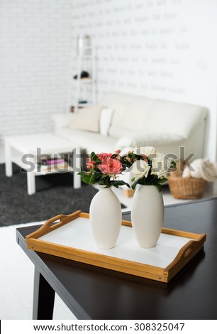 Simple home interior decoration, vase of flowers on a table in the interior of modern apartment