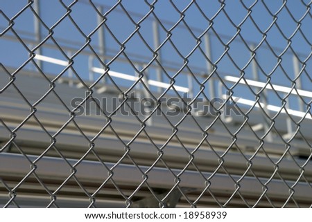 Bleachers in a stadium or school for the fans behind a fence.