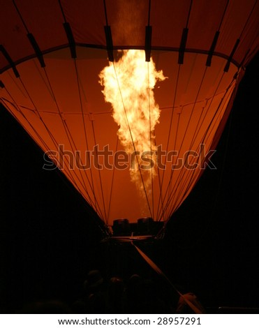 Hot air balloon with flames from the burner at night to show a glow.