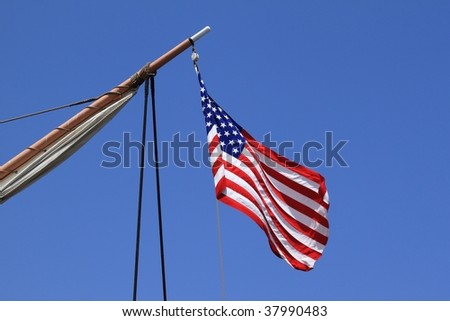 USA flag on an old sail ship with blue sky as background