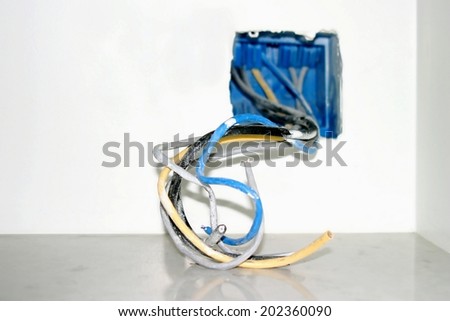 Wire box with different colored cables for power outlet installation.