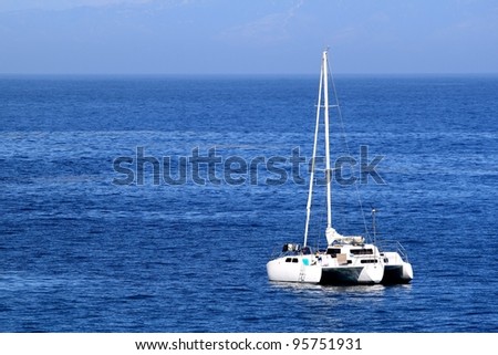 Sailboat anchoring in nice blue ocean water and sky.