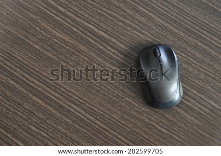 Wireless Mouse on wood background with text space