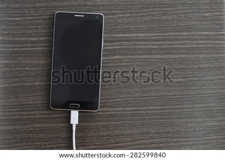 Smart phone Charging On Wood background