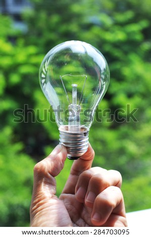 hand holding Green lamp eco light bulb energy concept