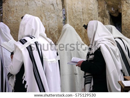 Orthodox Jews wearing tallit prayer shawls praying at the Western wall