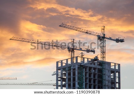 Construction site with cranes against the background of the evening sky