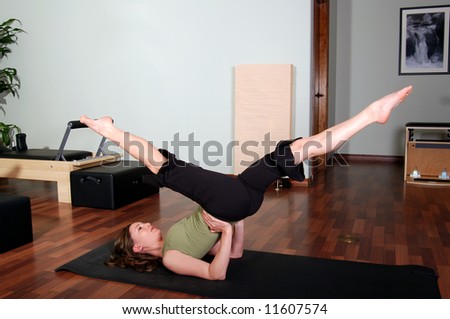 Pretty Young Pilates Instructor Performing Floor Excercise