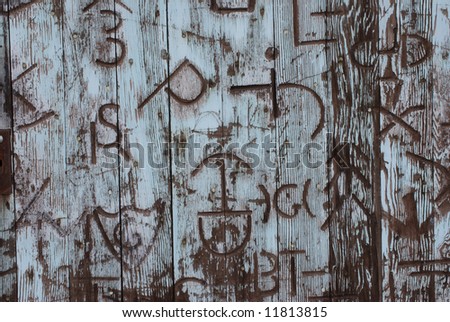 Horizontal image of an old door covered in western branding iron marks