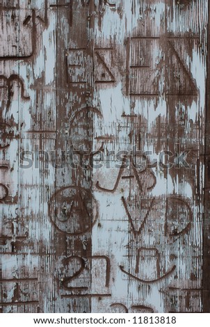 Vertical image of an old door covered in western branding iron marks