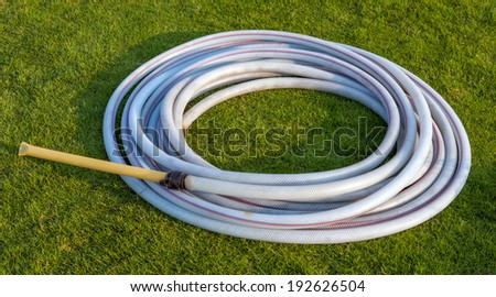 Round pattern rubber band on green grass field for watering plant in the garden