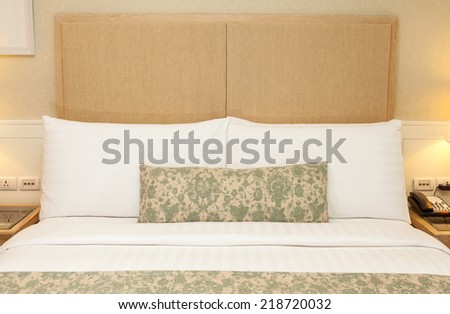 Hotel room setting with king sized bed, decorate with pillows, cover blanket, lamp, telephone in hotel Thailand