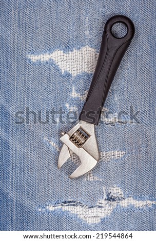 A part of pliers black handle tool with old blue jeans background, concept for fixing and useful maintenance.