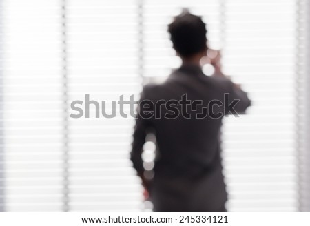 Blurred picture of young business man negotiate about his task near the window in office building.