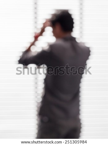 Blurred picture of young businessman in office is forced by under pressure from competitors.