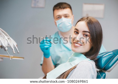 The girl is at the reception at the dentist. A happy client at the dentist smiles. . Dental bleaching. Dental clinic. Treatment of teeth in a modern clinic. Restoration of a healthy smile. Successful