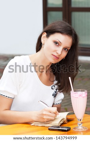 The girl in the cafe writing in a notebook