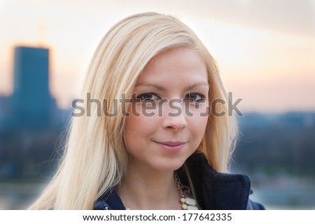 Close up portrait of a beautiful blonde girl with sunset in the background