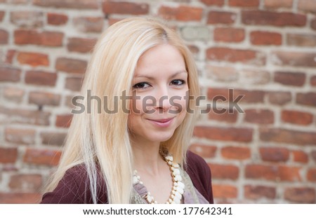 Close up portrait of a beautiful blonde girl over red wall background