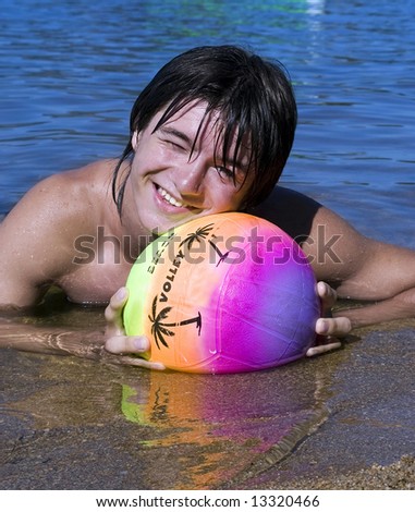 Teenager with variegated ball on the beach in summer vacation at Borovoe lake in Kazakhstan (series Teenagers)