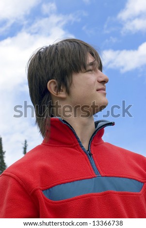 stock photo Pretty European teen boy in red sport pullover are looking up 