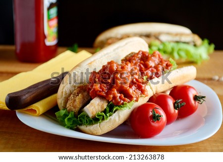 Chicken sandwich roll with roasted chicken breast, lettuce and spicy tomato sauce, close up