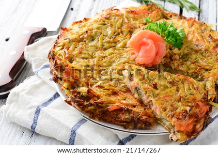 Potato latkes or fritters turned into big potato cake with gravlax, dill and parsley, close up