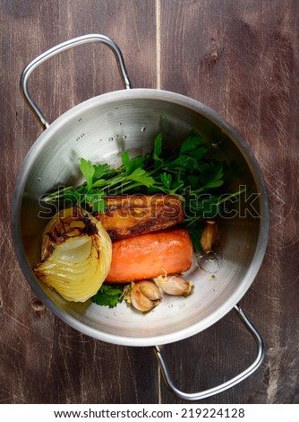 Cooking vegetable stock with roasted vegetables: carrots, garlic, parsley, onion and celery