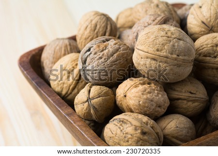 Organic walnuts in a wooden bowl, close up macro shot