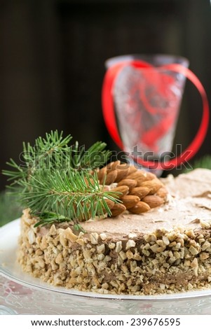 Almond chocolate cake decorated for Christmas with rosemary springs, pine tree branch and almond 
