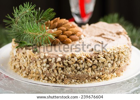 Almond chocolate cake decorated for Christmas with rosemary springs, pine tree branch and almond \