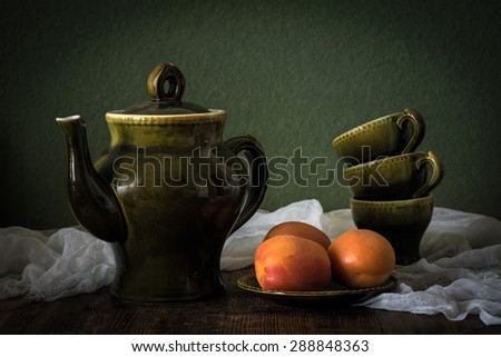Vintage still life of apricots and old porcelain tea cups and tea pot
