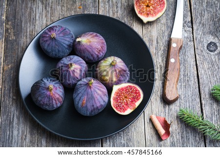 Figs on black plate on wooden table background