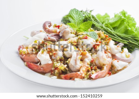 Spicy seafood salad , prawns , squid , oyster in dish on white background.