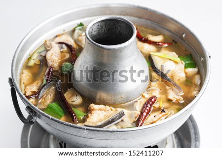 Mekong giant catfish and lemon grass soup with mushrooms in hotpot on white background.