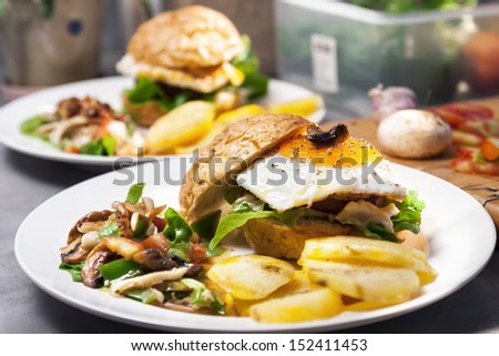 Egg burger , salad , boiled potatoes on kitchen background.