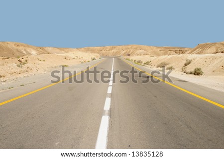 The highway winds among mountains in the Israeli desert and leads to the Dead Sea