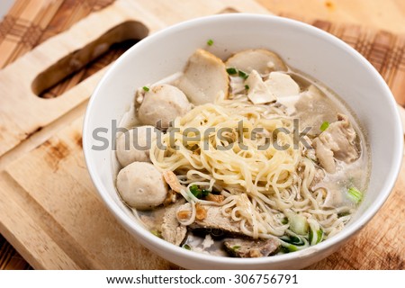 Rice Noodles Bone Soup with Meat Balls and Fish Balls on wood background,Thai food.