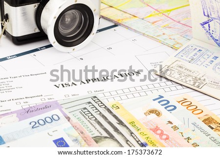 closeup visa application form, passport, camera and world currency. planning schedule for holiday and vacation