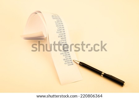 accounting concept with printout paper rolls and high quality pen in vintage retro style tone