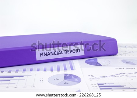 Purple binder of financial report place on graphs analysis of business annual reports