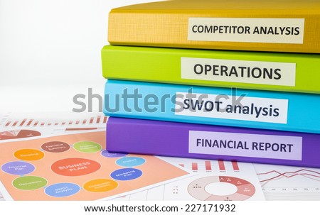 Colorful document binders: SWOT, competitor analysis, operation and financial report place on graph analysis and business plan chart, concept to business plan management