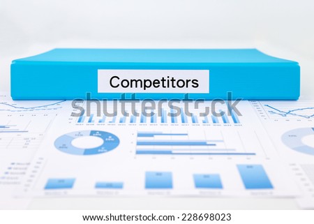Blue document binder with competitors word place on graph analysis, concept for business strategic planning