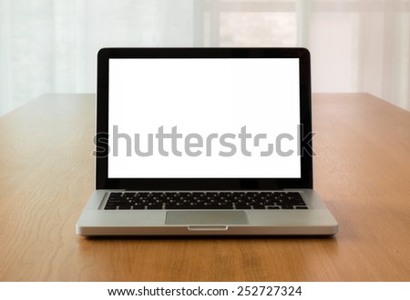 Open laptop with isolate screen on wooden desk with natural light coming through the window, Mock up concept and idea.
