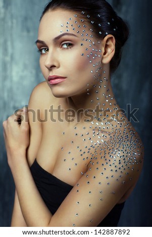 beautiful girl with elements of crystals on the face and body