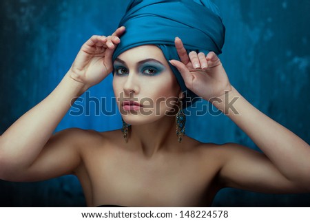 girl in oriental style. turban and earrings highlight its beauty