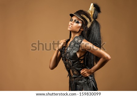 beautiful dark-skinned woman dressed in a military uniform Spartan force and ogres in her hands.